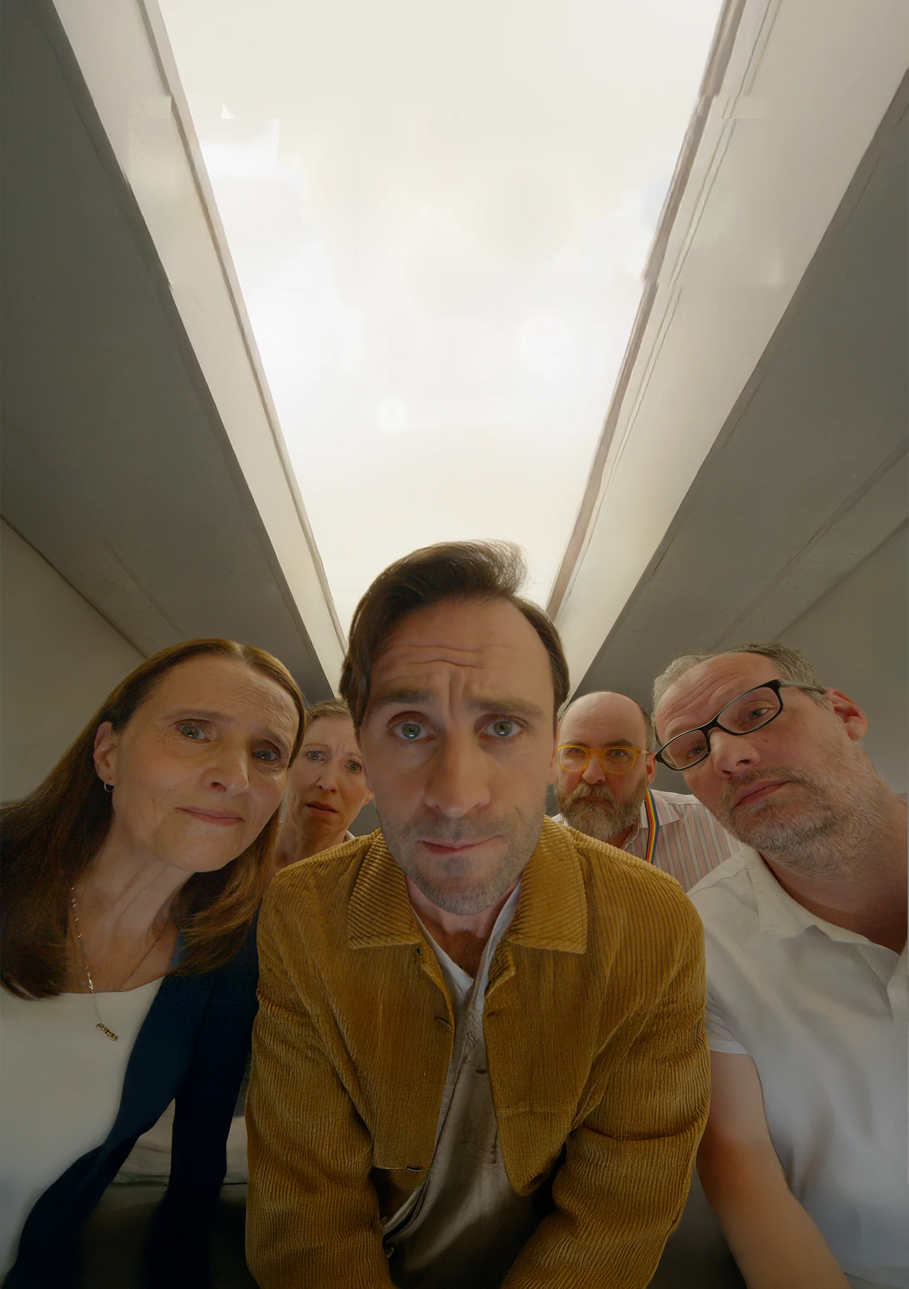 Mind The Gap: five people peer down into the camera along a narrow corridor ceiling
